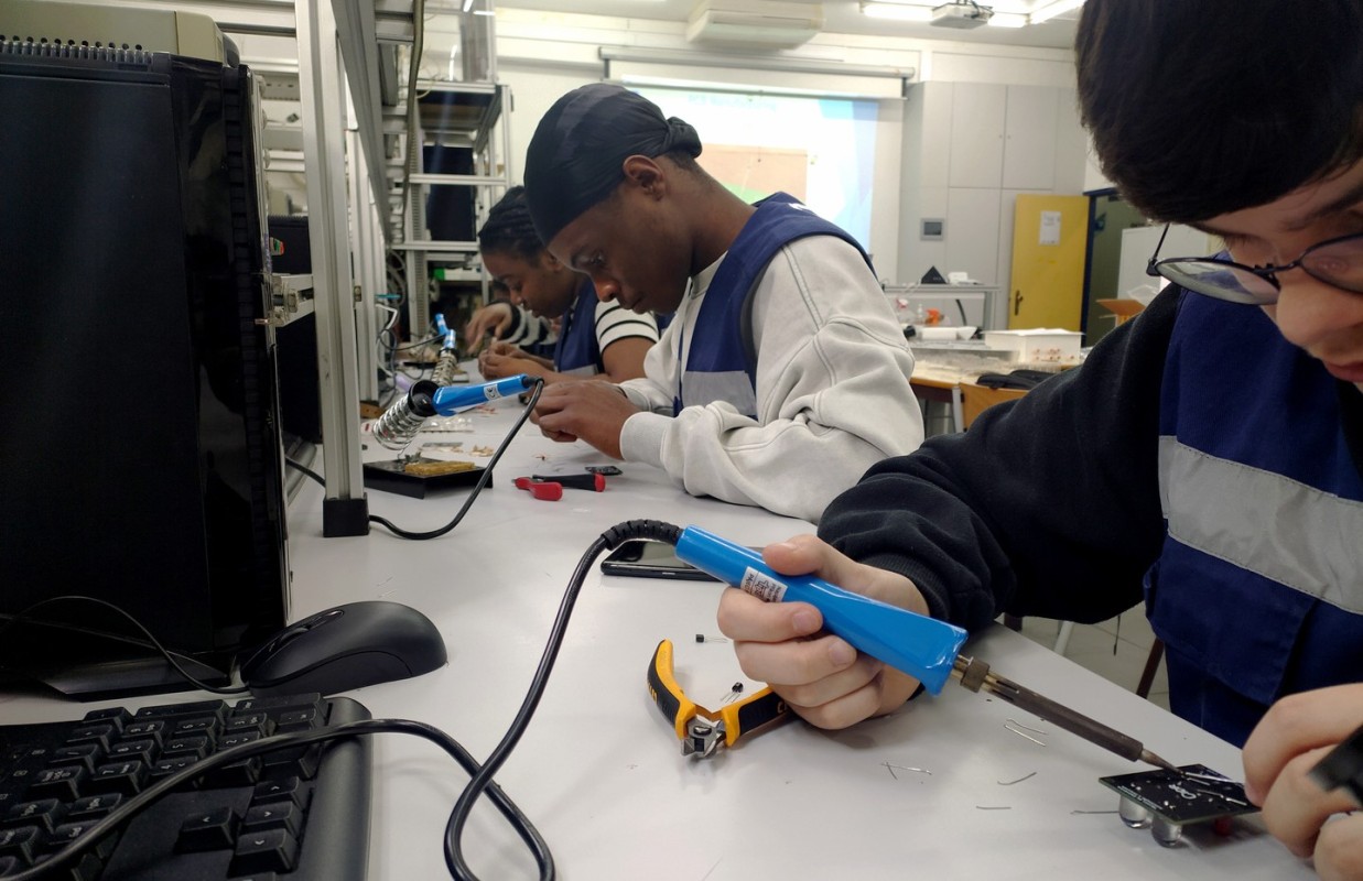Imagem de alunos sentados na sala de aula, perspetiva de costas