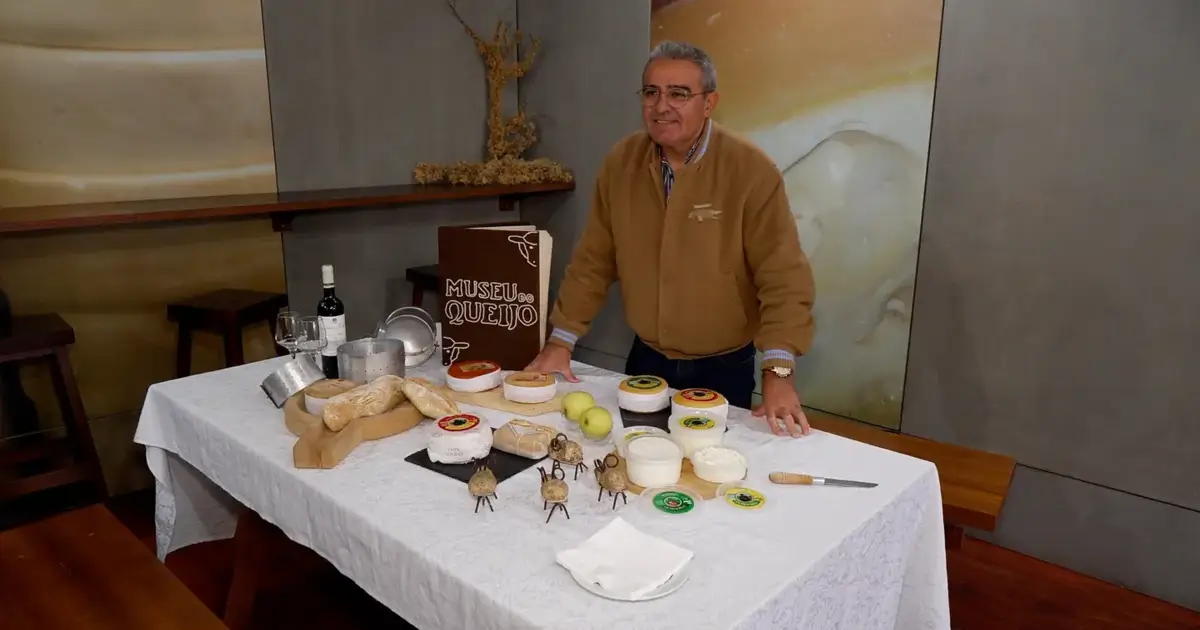 Fotografia ilustra o coordenador do Museu do Queijo junto a uma mesa com vários queijos e vinho